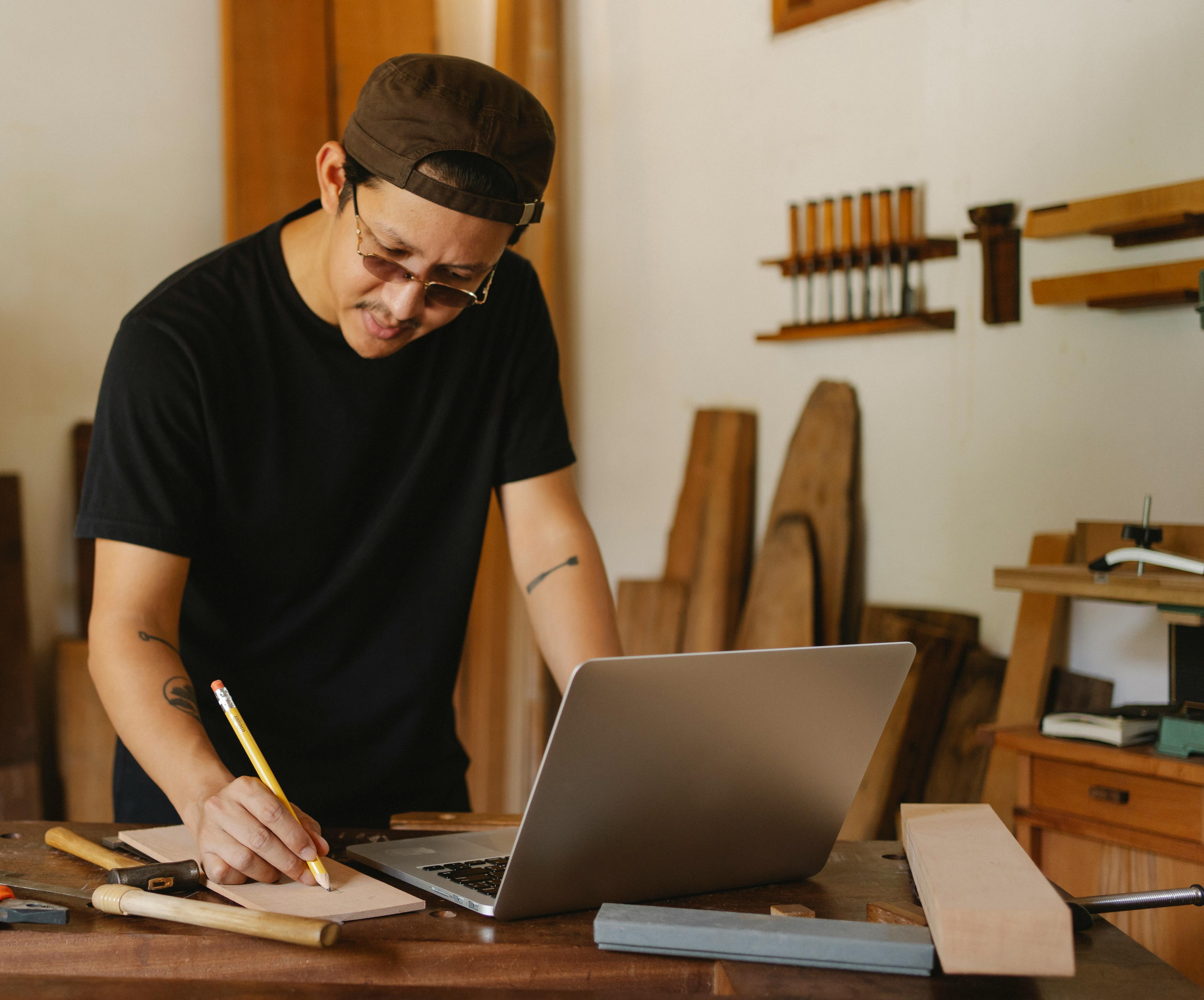 un artisan au travail qui regarde son ordinateur avec sont site web sur l'écran créé par Vincent Duguet, développeur web freelance à Tours